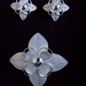 Délicate parure de trois bijoux: une paire de clous d'oreille et sa broche qui peut être portée en pendentif.